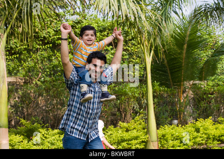 Ein Vater trägt seinen Sohn auf seinen Schultern Stockfoto