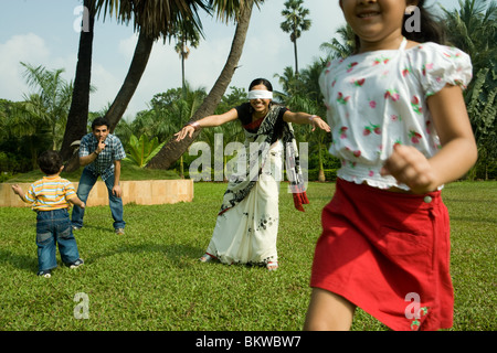 Familie spielen "Blind mans Bluff" in ihrem Garten Stockfoto