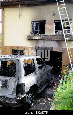 Ein verbranntes Haus und Auto nach Team Feuerwehr das Feuer, Asturien, Spanien löschte Stockfoto