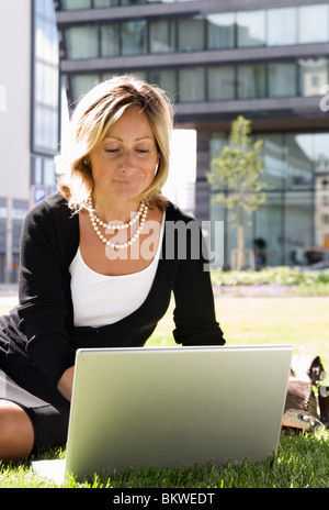 Geschäftsfrau im Park mit Laptop Stockfoto