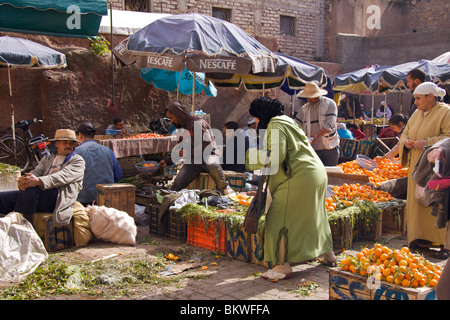 Frauen tragen Djellabahs und Schals Einkaufen für Obst und Gemüse aus männlichen Standinhaber in einem lokalen Markt in der Medina Stockfoto