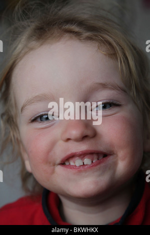 ZWEI JAHRE ALT MACHT GESICHT ESSEN LUSTIG: Zwei Jahre altes Kind Baby Mädchen macht ein Lächeln glücklich ziehen lustiges Gesicht Model veröffentlicht Stockfoto