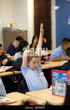 Schüler der Mittelschule erhebt seine Hand in seinem Klassenzimmer zur Charta Schule Peak Preparatory Academy in Dallas, Texas, USA Stockfoto