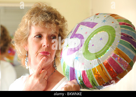 Blonde Frau sieht traurig unglücklich elenden Solothurn 50. Geburtstag mit Helium-Ballons Stockfoto