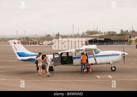 Passagiere, die umarmt im Relief nach der Landung sicher aus holprigen Flug über die Linien von Nasca, Peru Stockfoto