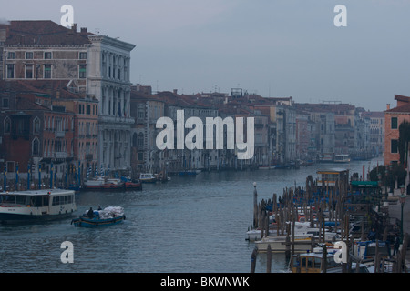Blick von der Rialto-Brücke des Canal Grande und am Flussufer Gebäude mit der Vaporettos, festgemacht Gondeln im Licht der Morgendämmerung Stockfoto