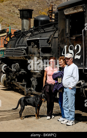 Stock Foto von Touristen posiert mit abgestellten Lokomotive, Durango and Silverton Narrow Gauge Railroad, Silverton, Colorado, USA. Stockfoto