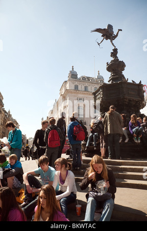 Teenager Jugendliche Touristen rund um die Statue des Eros, Piccadilly Circus, London UK Stockfoto