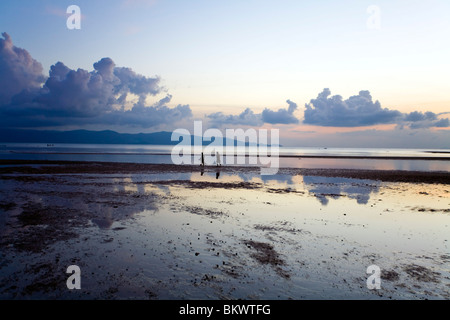 Zwei Personen Fuß entlang der Küste, während der Ebbe bei Sonnenuntergang ist Stockfoto