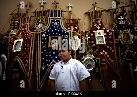 Ein Junge steht von Bannern aus verschiedenen katholischen Bruderschaften vor einem Karwoche feiern in Oaxaca, Mexiko, April 10 Stockfoto