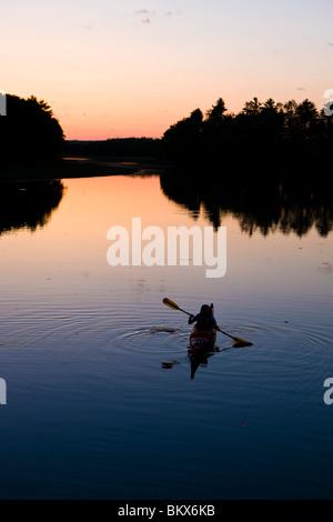 Eine Frau Kajaks am Oberlauf des Flusses York in York, Maine.  High Tide.  Sonnenuntergang. Stockfoto