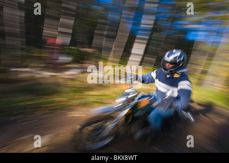 Ein Mann reitet auf seinem Motorrad durch den Wald bei Jericho Mountain State Park in Berlin, New Hampshire.  White Mountains. Stockfoto