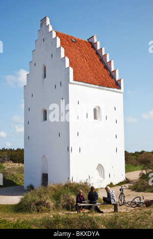 Der Sand verschlungen Buried Kirche von Skagen. Dänemark. Mit drei jungen Mädchen auf einer Bank Stockfoto