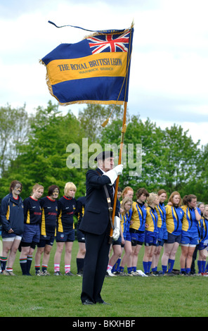 Mitglied der British Legion mit erhöhten Flagge bei der Wiedergabe des letzten Beitrags Stockfoto