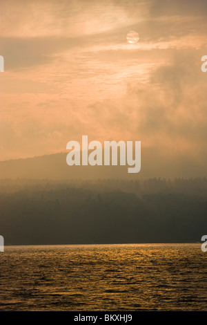 Die Sonne brennt durch den Nebel am Lake Sunapee State Beach in Newbury, New Hampshire. Stockfoto
