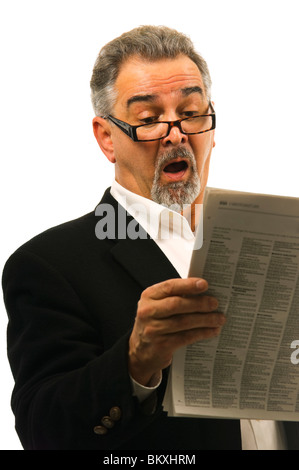 Ein mit offenem Mund reifer Mann schaut überrascht; schockiert; ehrfürchtig beim Lesen einer Zeitungs. Stockfoto