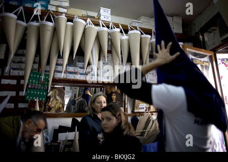 Ein Kunde testet einen reuigen Hut für Beeing verwendet in der Karwoche in einem Familie Geschäft in Sevilla in der spanischen Region Andalusien Stockfoto