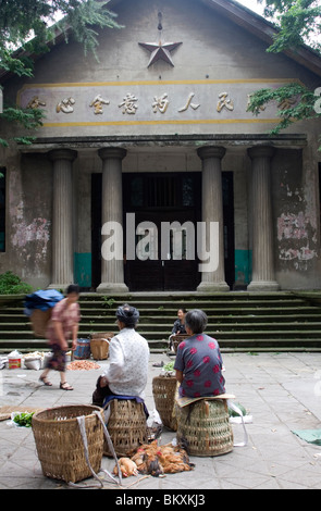 Markt mit frischen Lebensmitteln außerhalb eines alten Verwaltungsgebäude mit kommunistischen Stern und Mao Zedong sagte in der Zeche Stadt in Sichuan. Stockfoto