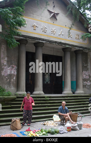 Markt mit frischen Lebensmitteln außerhalb eines alten Verwaltungsgebäude mit kommunistischen Stern und Mao Zedong sagte in der Zeche Stadt in Sichuan. Stockfoto