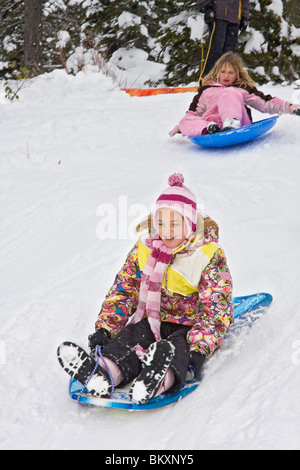 Kinder-Schlitten auf kurze Piste im Winter, South Lake Tahoe, Kalifornien, USA. Hier kommen die Mädchen den Hügel hinunter. Stockfoto