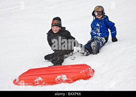 Kinder-Schlitten auf kurze Piste im Winter, South Lake Tahoe, Kalifornien, USA. Hier entwirren zwei jungen sich nach einem Absturz. Stockfoto