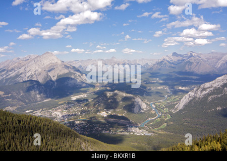 Die Stadt von Banff und Bow River am Talboden mit den Rocky Mountains, rund um die Stadt mit blauen Himmel und hohe Wolken Stockfoto