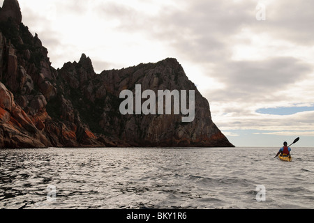 Ein Kajakfahrer Meer Paddel um Klippen auf Schouten Insel, Freycinet National Park, Tasmanien, Australien. Stockfoto