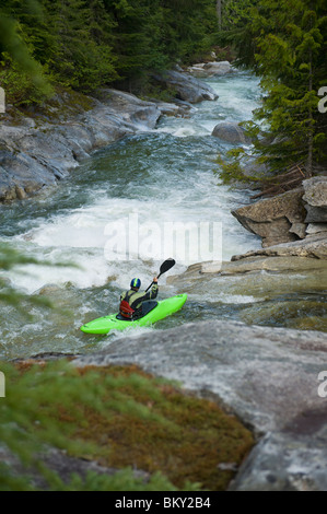 Ein Wildwasser-Kajakfahrer richtet für ein Tropfen auf einem hohen Bergfluss. Stockfoto