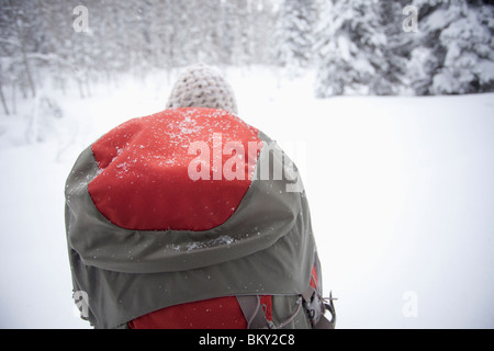 Eine junge Frau Wanderungen mit einem Rucksack im frischen Pulverschnee in den Wasatch Mountains, Utah. Stockfoto