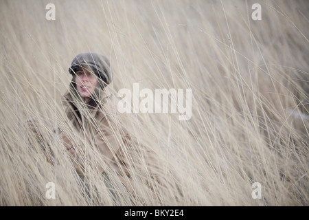 Junge Frau verbirgt sich im Bereich der Winter Rasen. Stockfoto