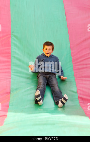 Ein MODEL Release Bild eines jungen auf einer Folie Wroxham Scheunen Jahrmarkt in Wroxham, Norfolk, England, Großbritannien, Uk Stockfoto