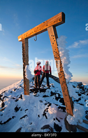 Zwei Personen sind eingerahmt von einem Holztor auf dem Mount Fuji, Honshu, Japan. Stockfoto