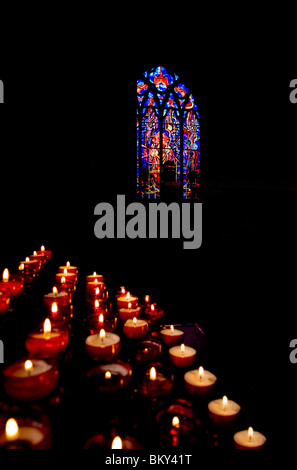 Kerzen und Harry Clarke die Buntglasfenster im 13. Jahrhundert Dominikanische schwarzen Kloster Stadt Kilkenny, Irland Stockfoto