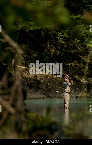 Ein Mann wirft in einem Fluss tragen Waders beim Fliegenfischen in Squamish, Britisch-Kolumbien. Stockfoto