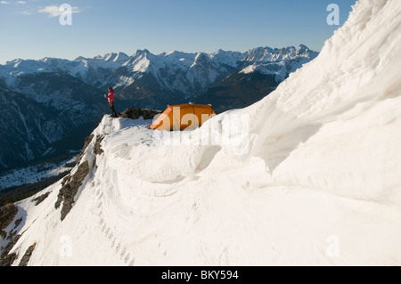 Eine Frau, camping auf einem verschneiten Bergrücken oberhalb Molas Pass, San Juan National Forest, Colorado. Stockfoto