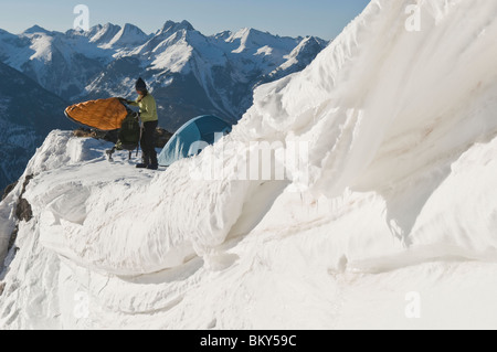 Eine Frau, camping auf einem verschneiten Bergrücken oberhalb Molas Pass, San Juan National Forest, Colorado. Stockfoto