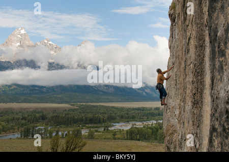 Ein Mann Klettern eine Felswand unterhalb der Tetons, Black Tail Butte, Jackson, Wyoming. Stockfoto