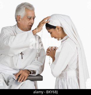 Nonne mit einem Priester ihre Sünden bekennen Stockfoto