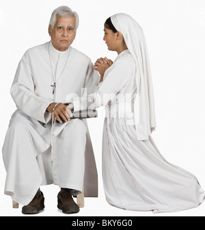 Nonne mit einem Priester ihre Sünden bekennen Stockfoto