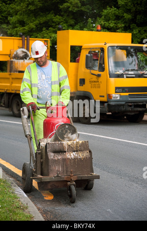 Eine einzelne gelbe Linie auf der Straße, mit Support für LKW im Hintergrund, UK Bild Mann. Markierung Parken Einschränkung, GB. Stockfoto