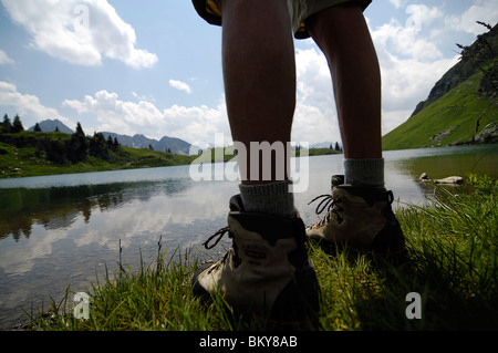 Blick auf die Beine der Wanderer vor einem Bergsee, Allgäuer Alpen, Bayern, Deutschland, Europa Stockfoto
