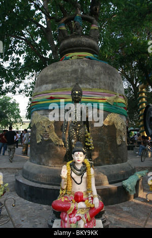 Statue von Shiva und Buddha vor einer Glocke am Wat Bang Phra, ein buddhistischer Tempel in Thailand, wo Mönche Anhänger tattoo. Stockfoto