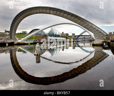 Millennium Bridge am Fluss Tyne Gateshead Winking blinken Augenhöhe mit Spiegelbild im Fluss Tyne Salbei im Hintergrund dem Erdboden gleichgemacht Stockfoto