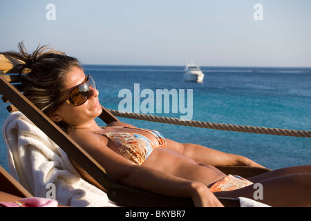 Zwei Frauen sitzen in Liegestühlen auf der Terrasse des Goya-Beach-Bar, der einzige Strand Bar mit Pool, Paranga Beach, Mykonos, Griechenland Stockfoto