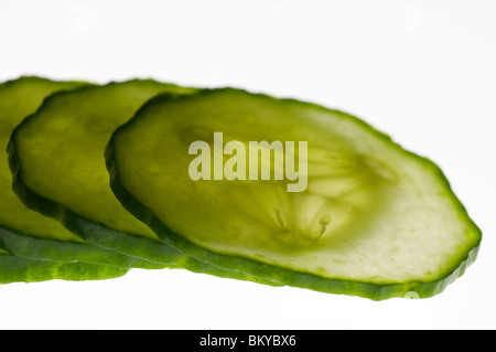 dünne Scheiben Gurke von hinten angestrahlt und vor einem weißen Hintergrund isoliert Stockfoto