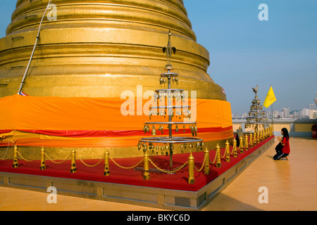 Frau beten vor vergoldeten Chedi befindet sich eine Reliquie des Buddha des Wat Saket auf der Golden Mount, Bangkok, Thailand Stockfoto