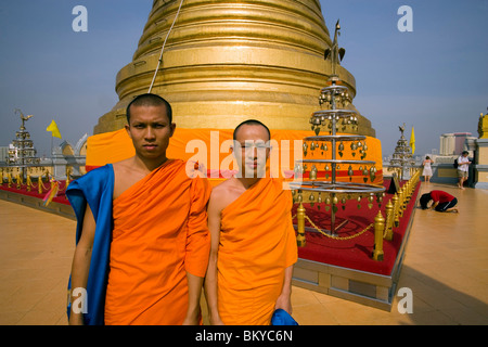 Zwei Mönche vor untergebracht der vergoldeten Chedi, ein Relikt der Buddha des Wat Saket auf der Golden Mount, Frau im Hintergrund, Verbot zu beten Stockfoto