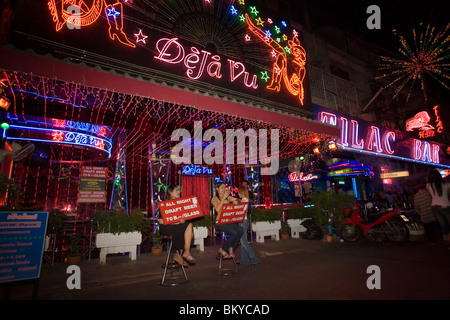 Frauen sitzen vor der Go-Go-bar "DeJa Vu" und präsentiert Zeichen, Soi Cowboy, ein Rotlicht - Viertel, Th Sukhumvit, Bangkok, Tha Stockfoto