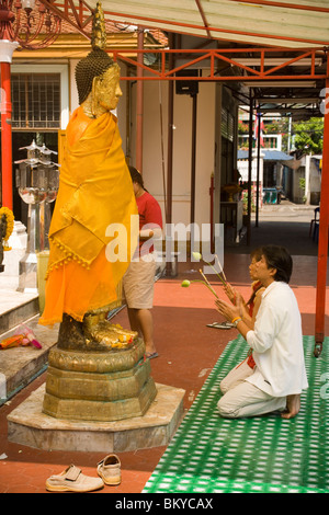 Frauen beten vor der vergoldete Buddha-Statue, Wat Intharawihan, Banglamphu, Bangkok, Thailand Stockfoto