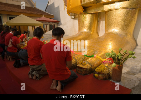 Menschen beten vor der vergoldeten Buddha-Statue, 32 m hoch, Wat Intharawihan, Banglamphu, Bangkok, Thailand Stockfoto